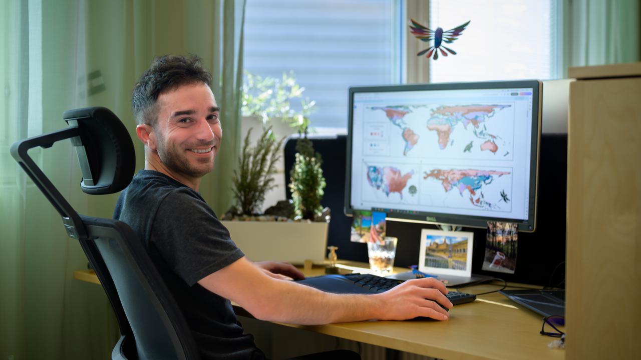 A man is sitting at a desk with a computer.