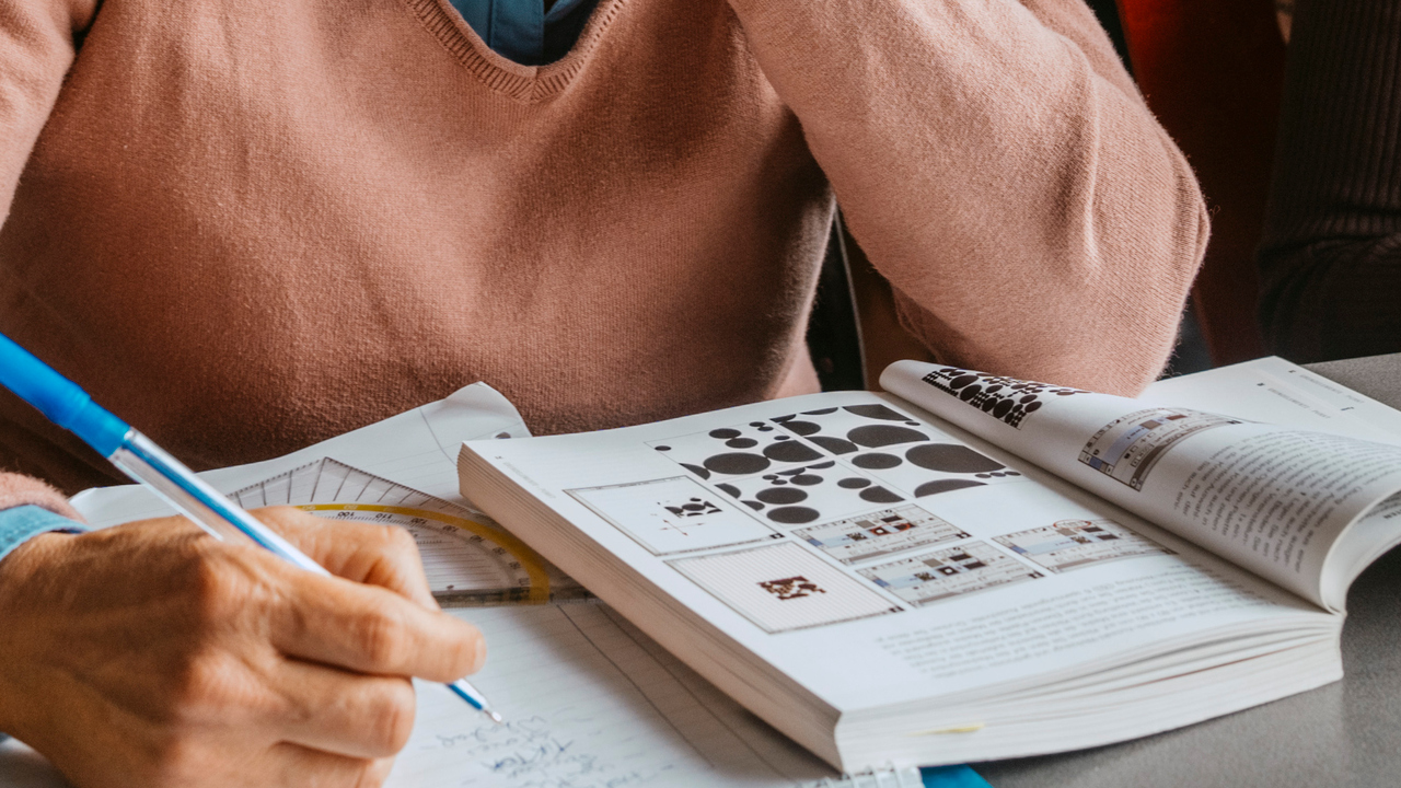 Foto av hand och skolbok