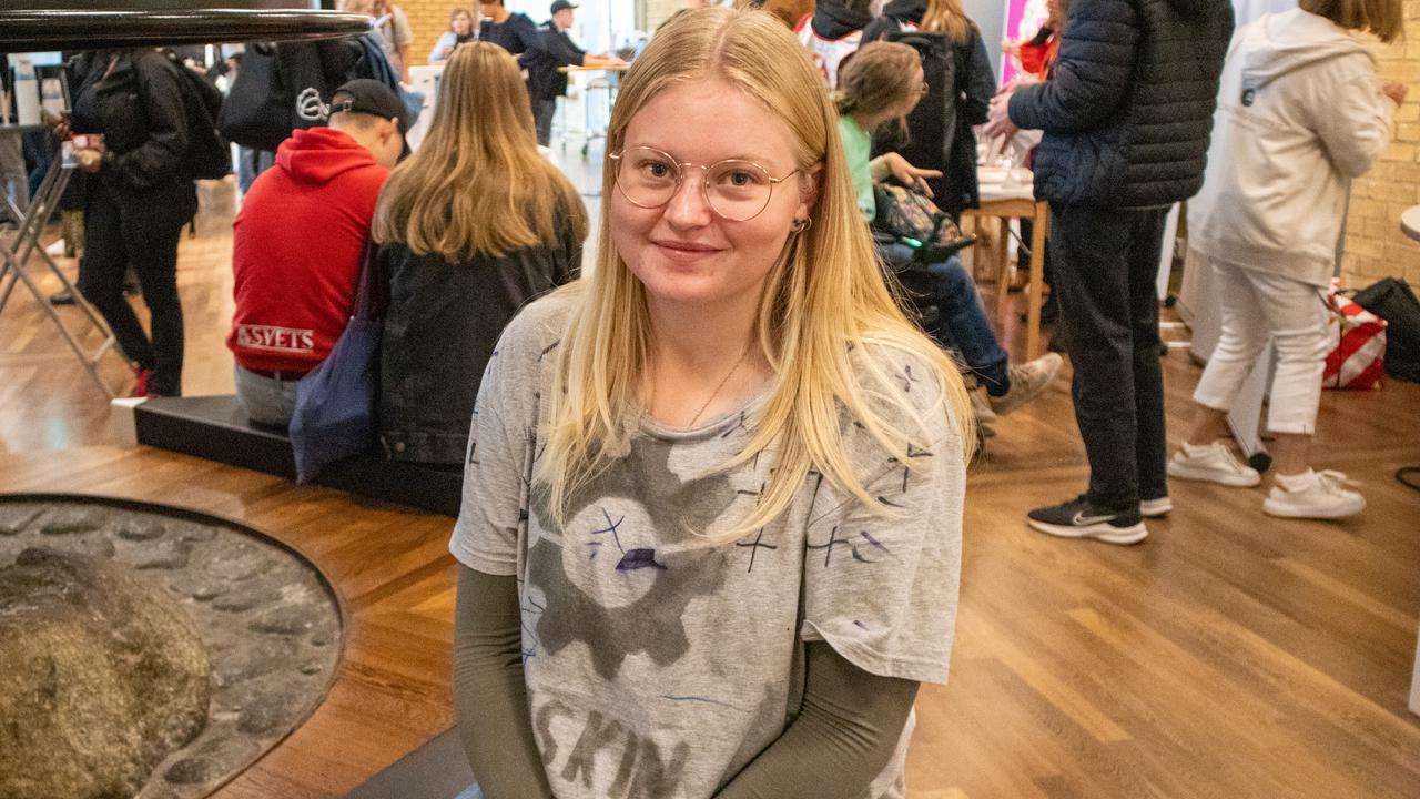 Bild på Saga Karlsson, student, sittande på bänk under mingel med studenter.