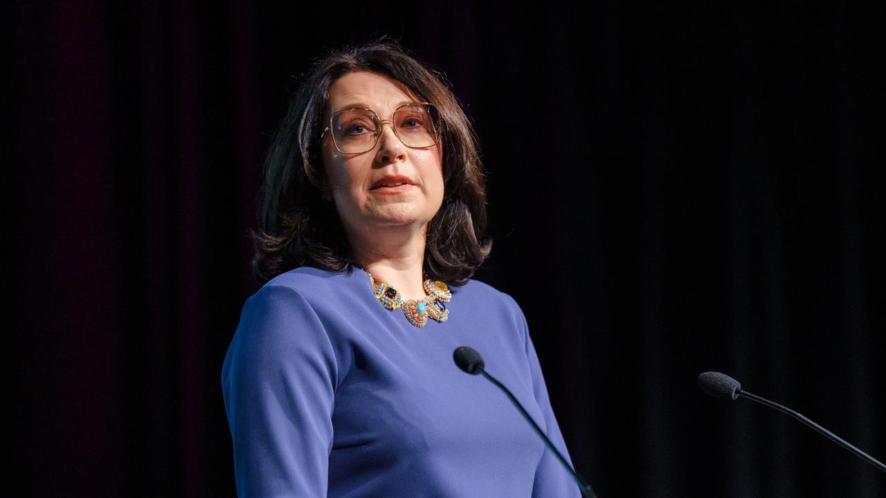 Alumni delivering a speech behind a podium at a ceremony.