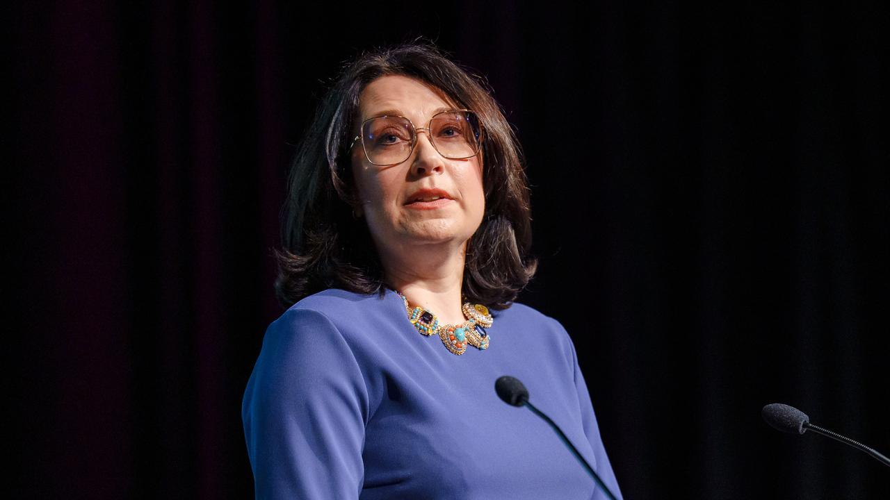 Alumni delivering a speech behind a podium at a ceremony.