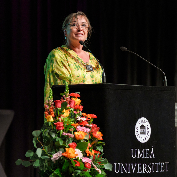 En kvinna står på ett podium framför en mikrofon.