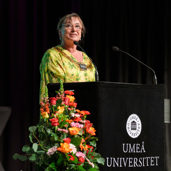 En kvinna står på ett podium framför en mikrofon.