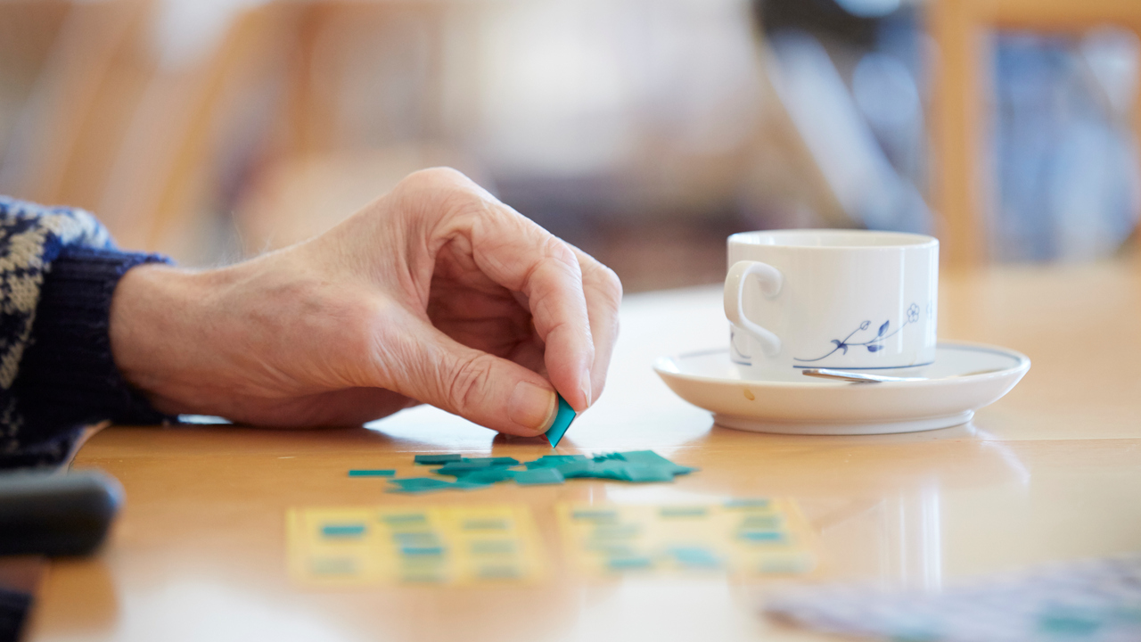 Närbild äldre hand som spelar bingo