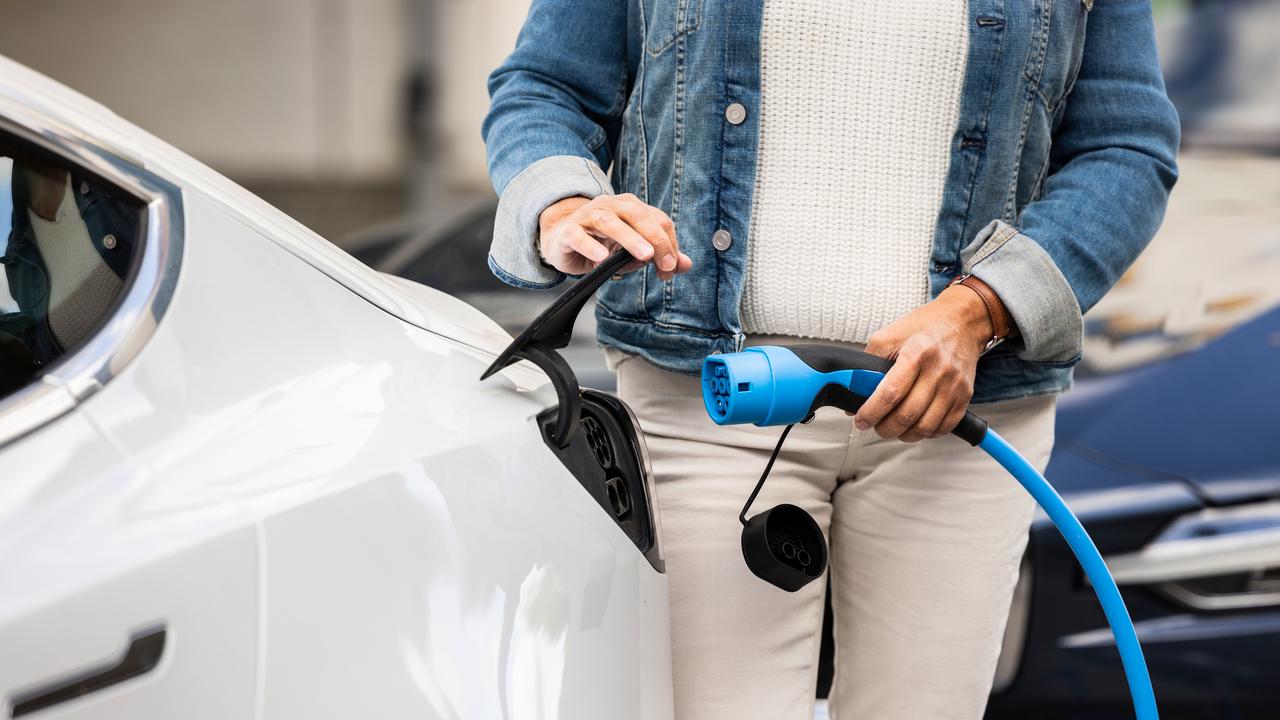 Bild på kvinna som sätter i kontakt för att ladda en elbil