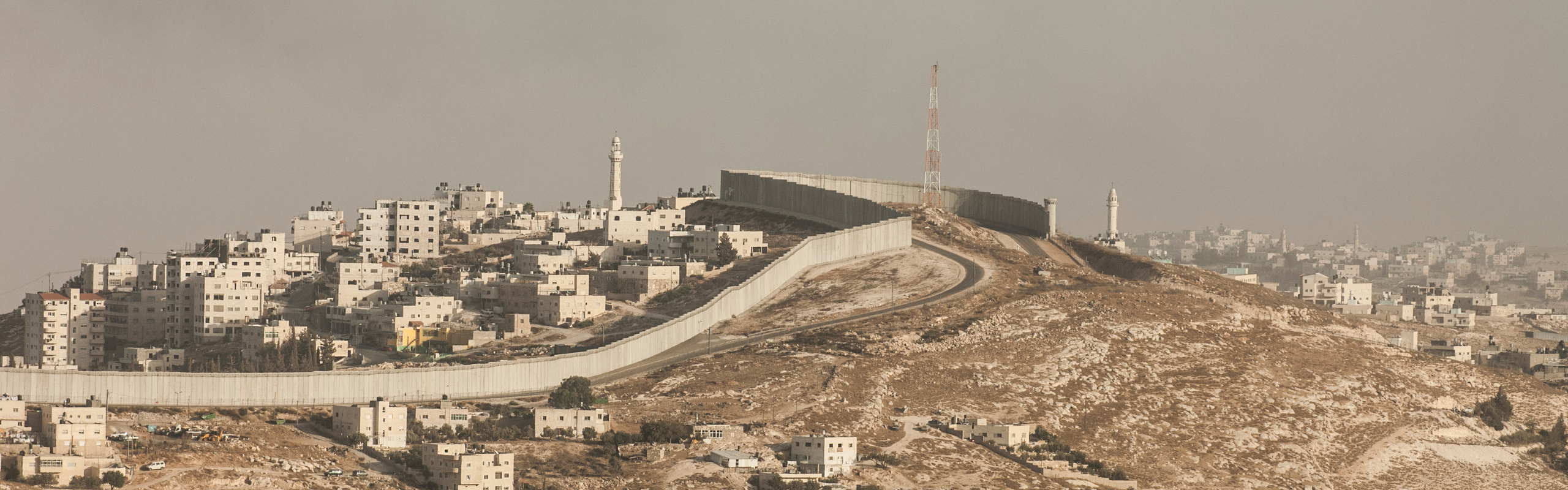 Översiktsbild på Jerusalem där en mur som Israel byggt löper genom staden och delar upp landet.