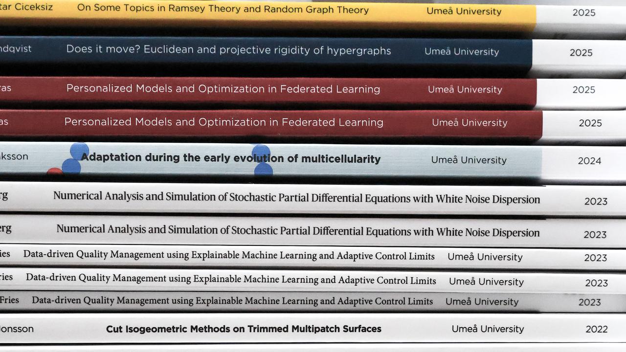 En stapel av doktorsavhandlingar i matematik och matematisk statistik vid Umeå universitet. Bokryggarna visar titlar, författarnamn och årtal, med färger som varierar mellan vitt, svart, blått, grått och rött.