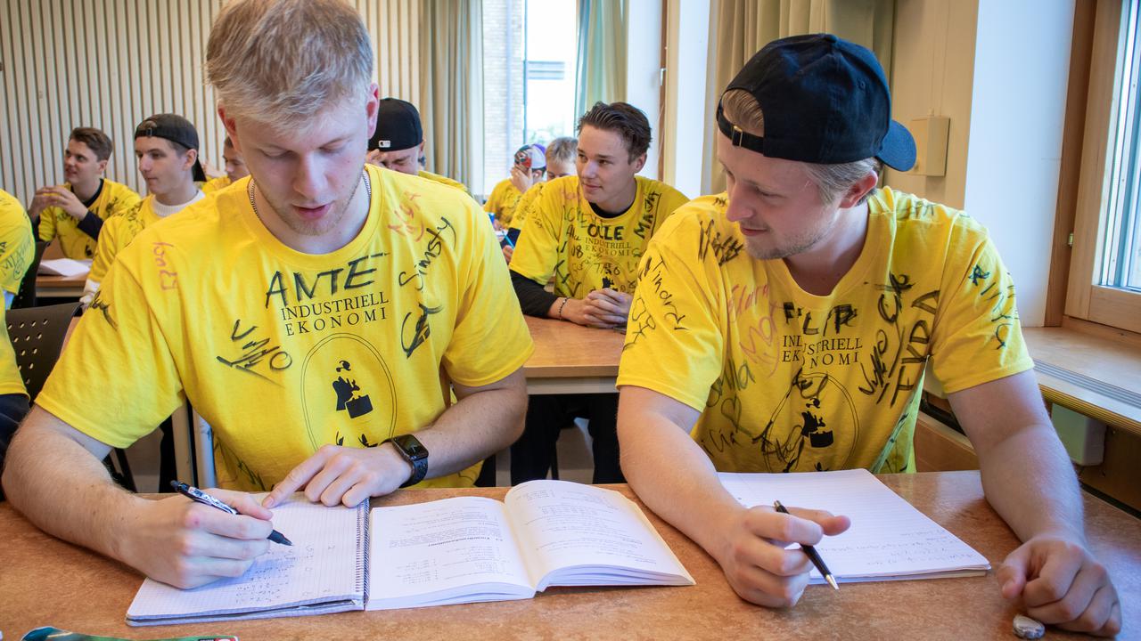 Bild på studenterna Ante Duveskog och Filip Blom som löser matematikuppgiifter i ett klassrum.