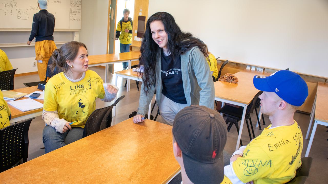 Bild på Olow Sande som diskuterar med studenterna Linna Hallin och Willian Wallberg i en lektionssal.