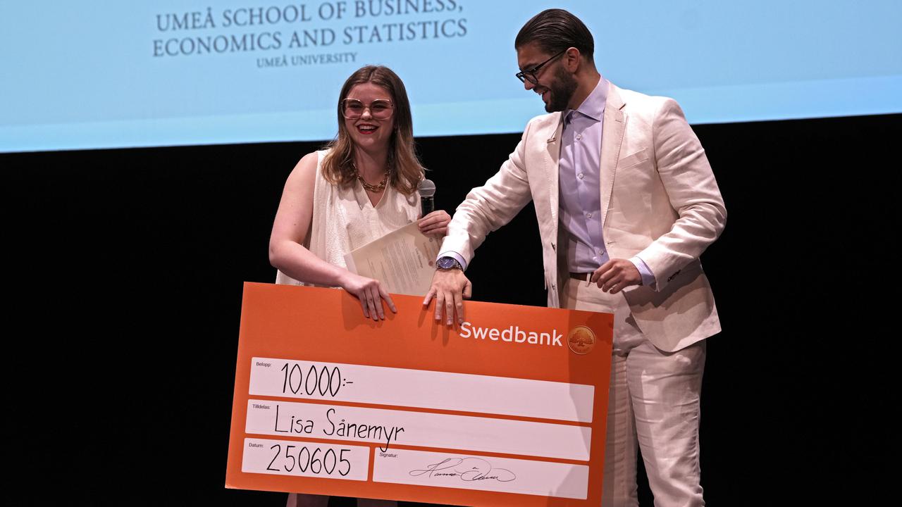 A man and a woman are holding a large check.