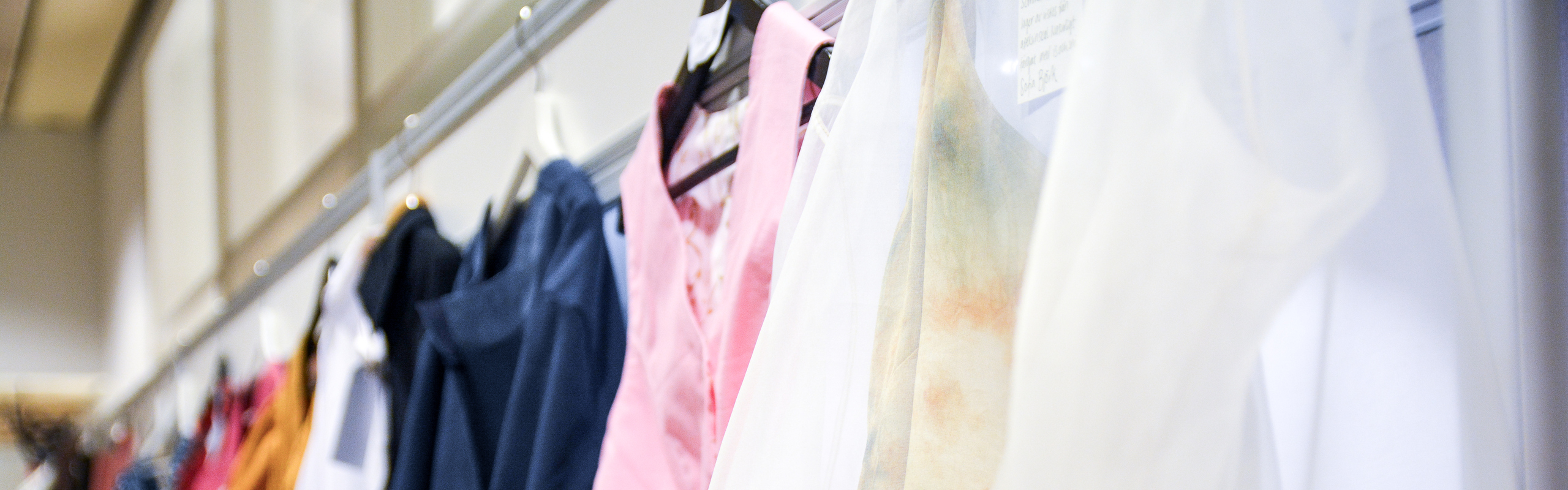 En rad kläder som hänger på klädhängare