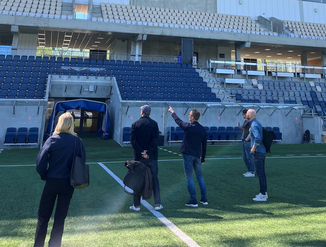 En grupp människor som står i mitten av en fotbollsarena.
