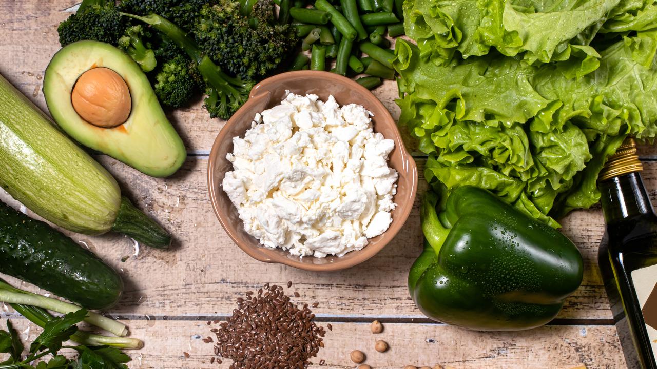 Nyttiga råvaror i form av grönsaker, baljväxter, olivolja och ost på ett bort.