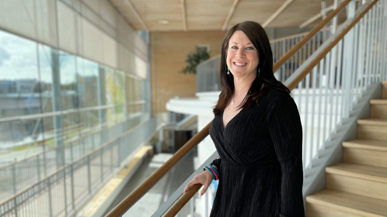 En kvinna står på trappan till en byggnad.