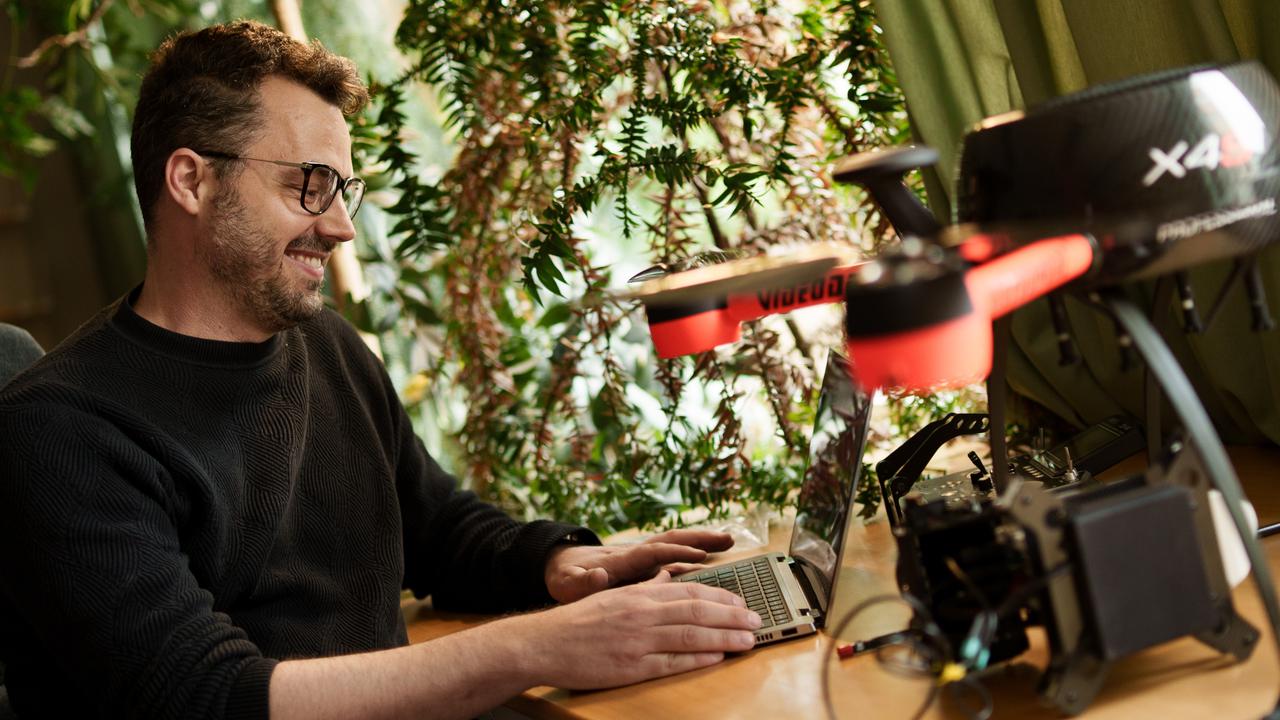 En man sitter vid ett skrivbord och använder en bärbar dator.