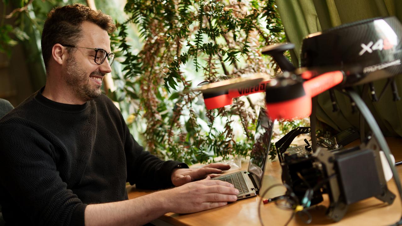 En man sitter vid ett skrivbord och använder en bärbar dator.