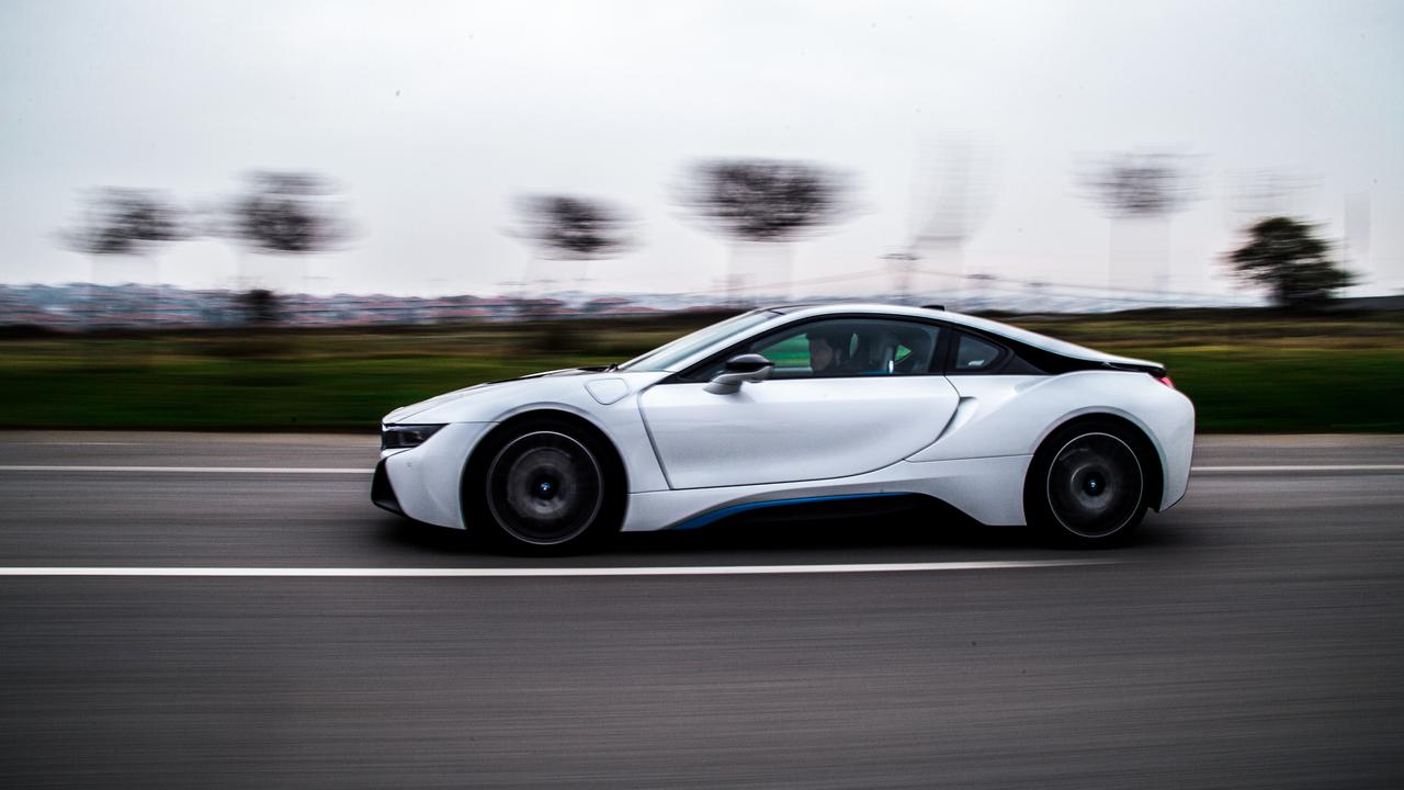 En vit sportbil som kör på vägen.