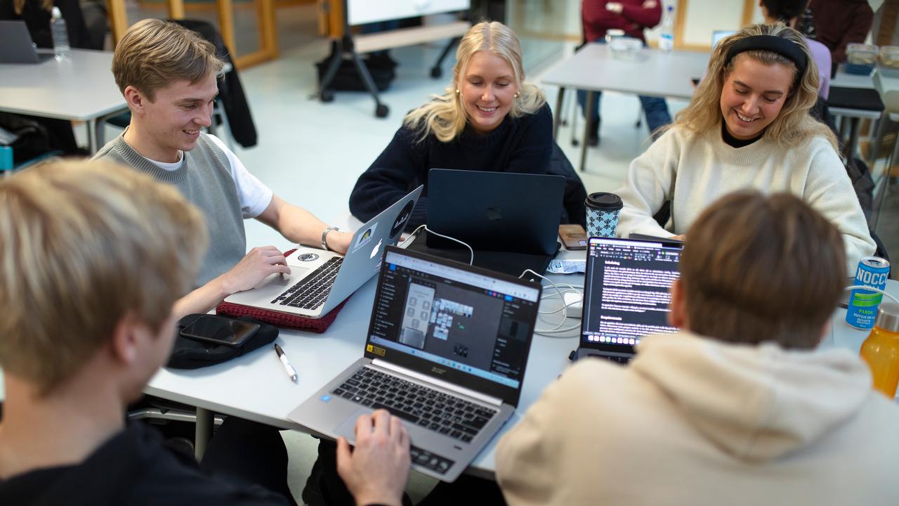 Students around a table with laptops