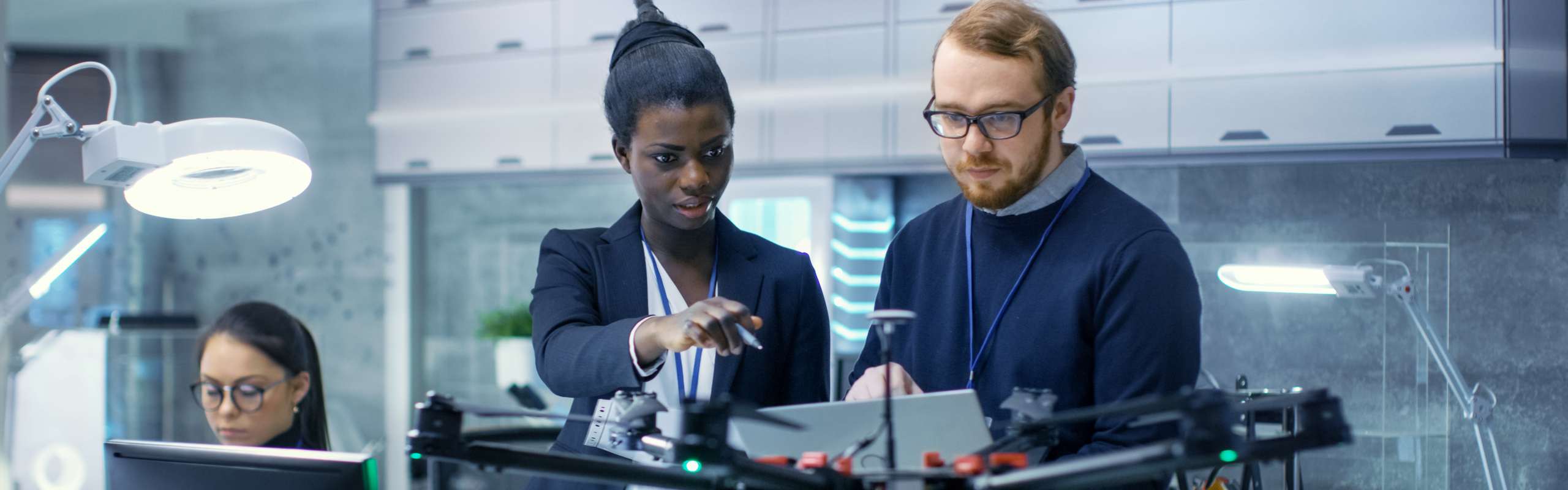 Bilden visar en man och en kvinna bakom en drönare.