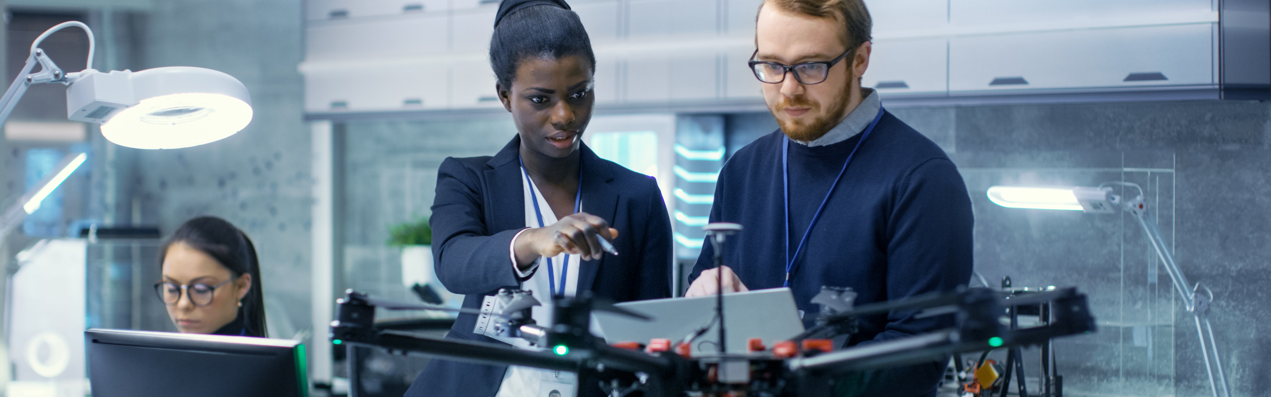 Bilden visar en man och en kvinna bakom en drönare.