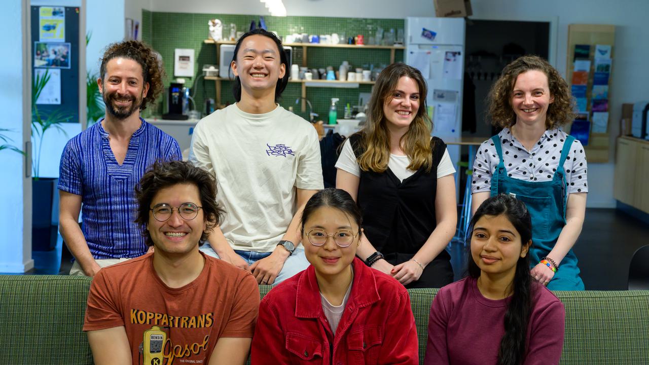 A group of people sitting on top of a green couch