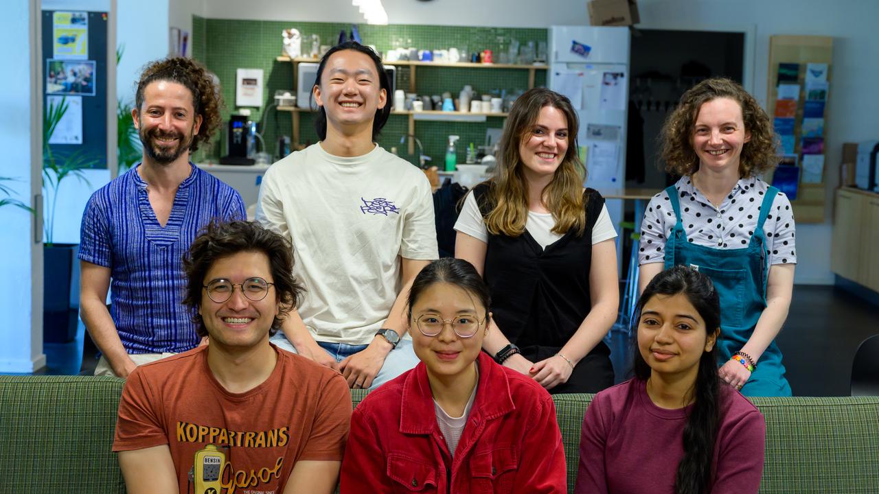A group of people sitting on top of a green couch
