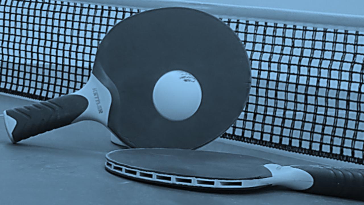 Two ping pong paddles and a racket on a tennis court.