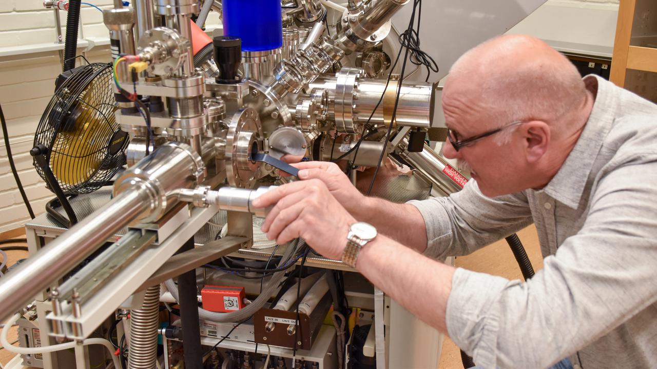 Andrey inserts a sample in the XPS-instrument.