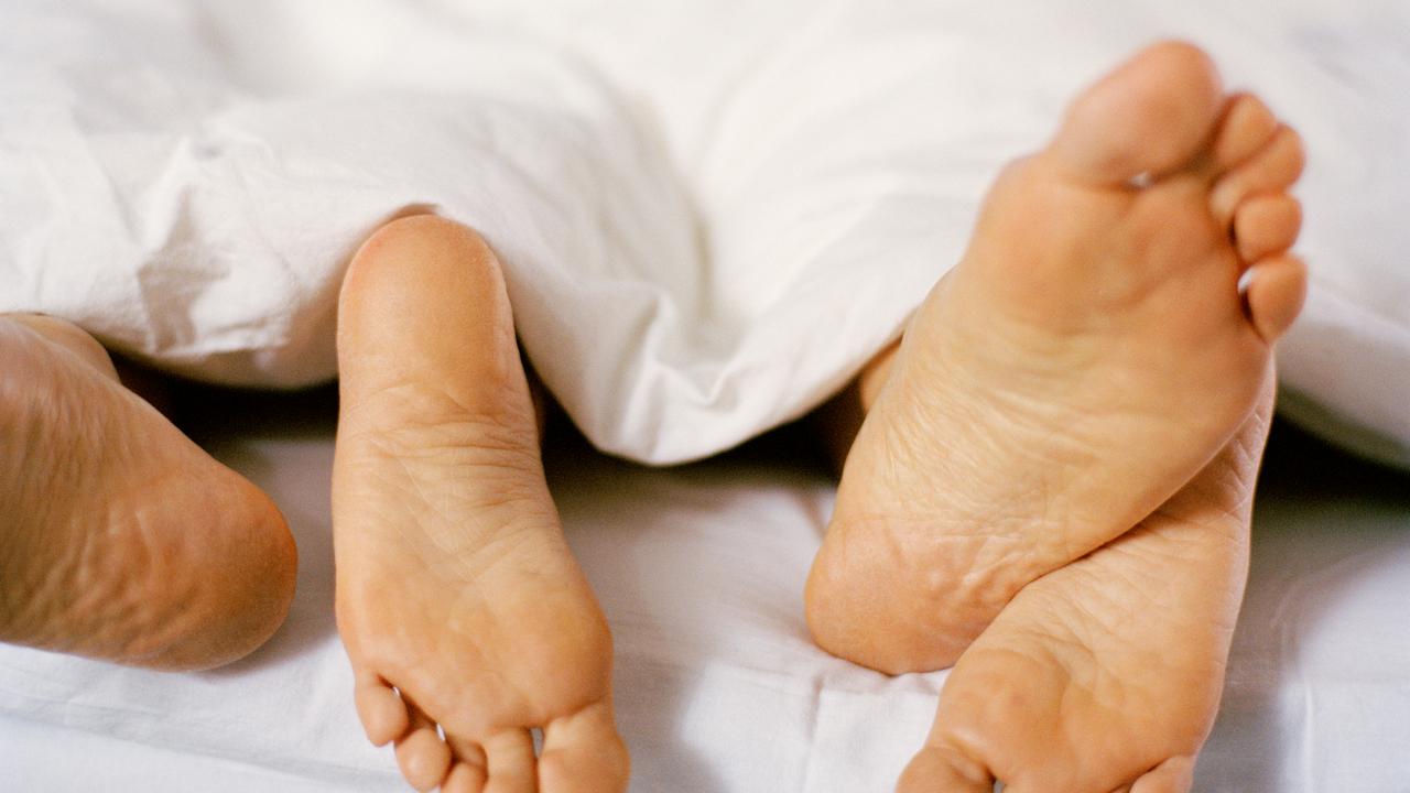 Fyra fötter sticker fram under täcke