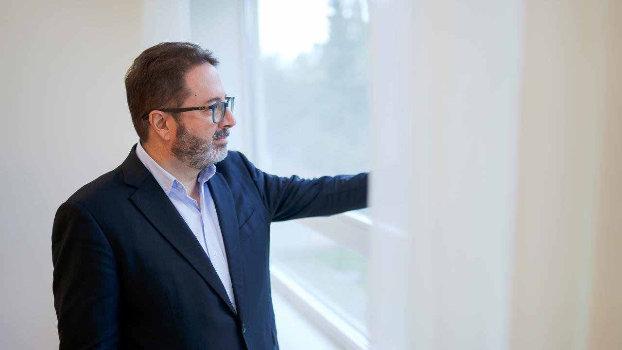 En man tittar ut genom ett fönster.