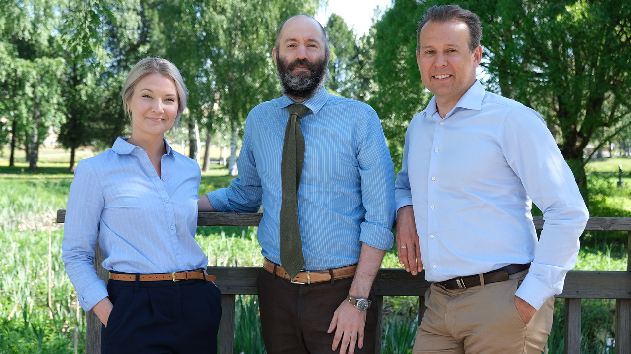 Therese Enarsson, Jan Leidö och Johan Holm står utomhus och lutar sig mot ett räcke. 