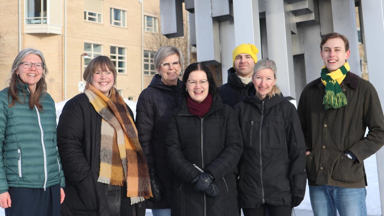 A group of people standing next to each other in front of the art object, Norra skenet, Umeå Campus