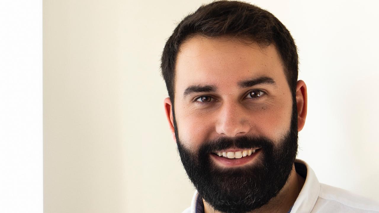 En man med skägg som bär en vit skjorta.