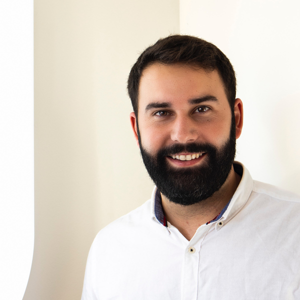 En man med skägg som bär en vit skjorta.