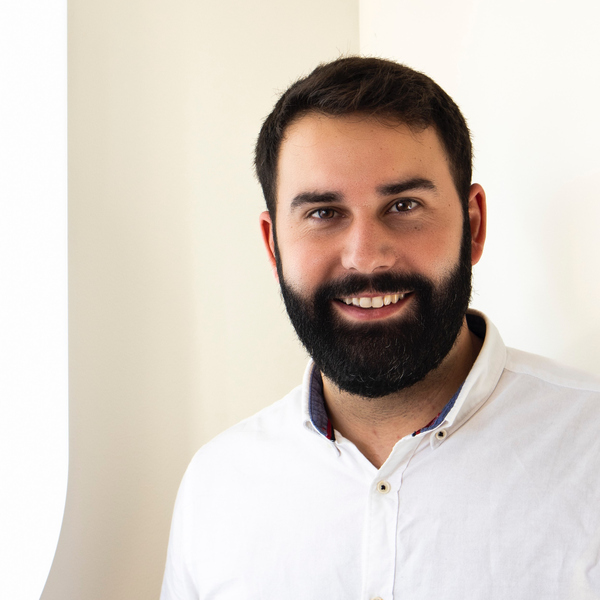 A man with a beard wearing a white shirt.