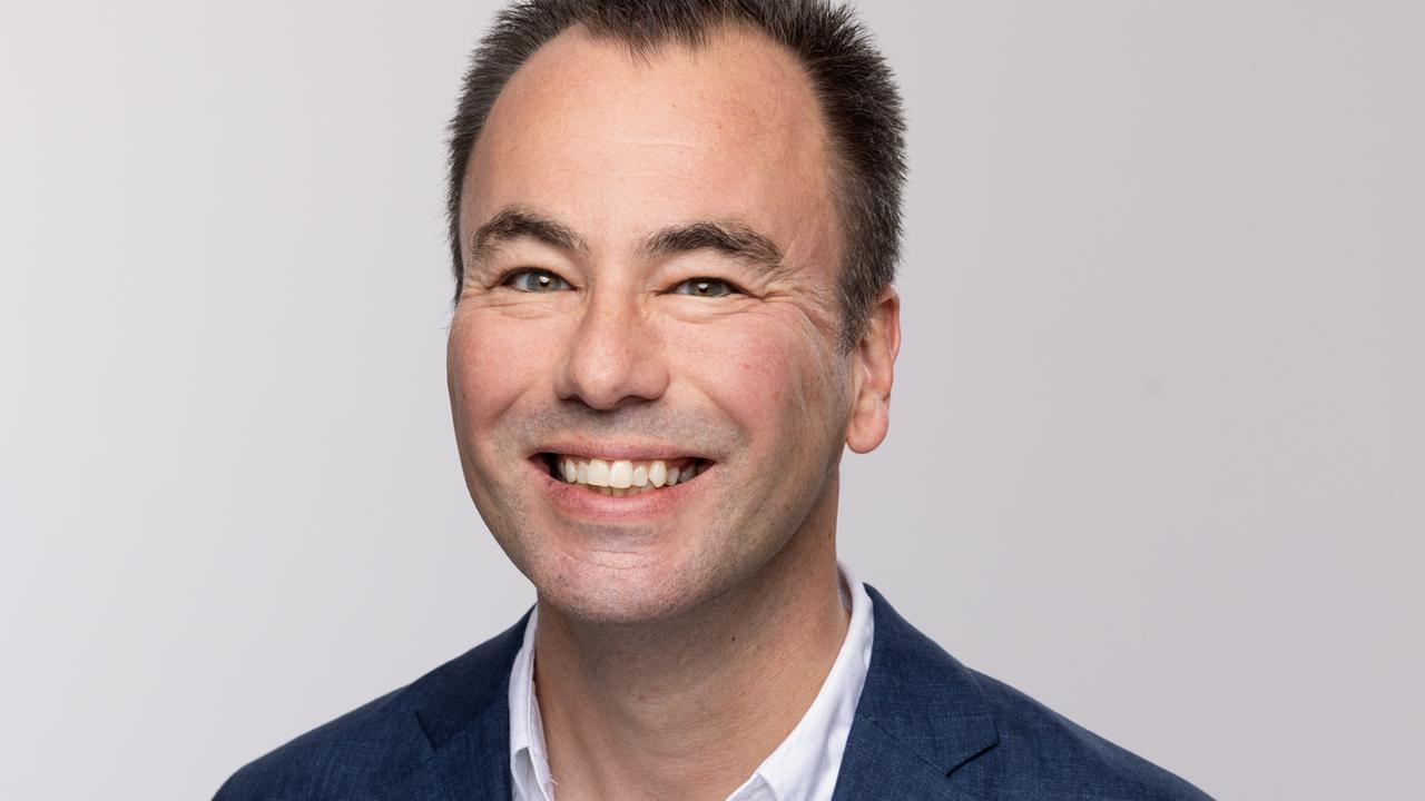 Porträttbild av föreläsaren Marcus Gustavsson tagen i fotostudio. Han har vit skjorta och marinblå kavaj på sig.