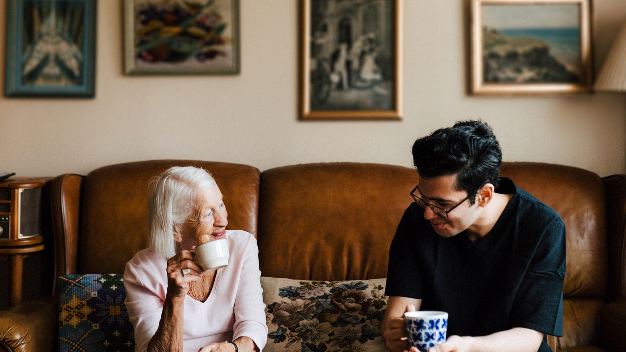 Yngre man och äldre kvinna dricker kaffe