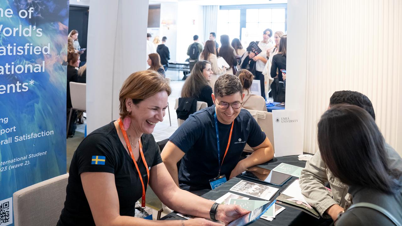 Representatives from Umeå University in a student fair, talking to prospective students.
