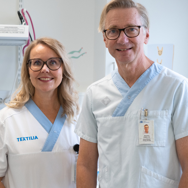 En man och en kvinna i läkarkläder som står bredvid varandra.