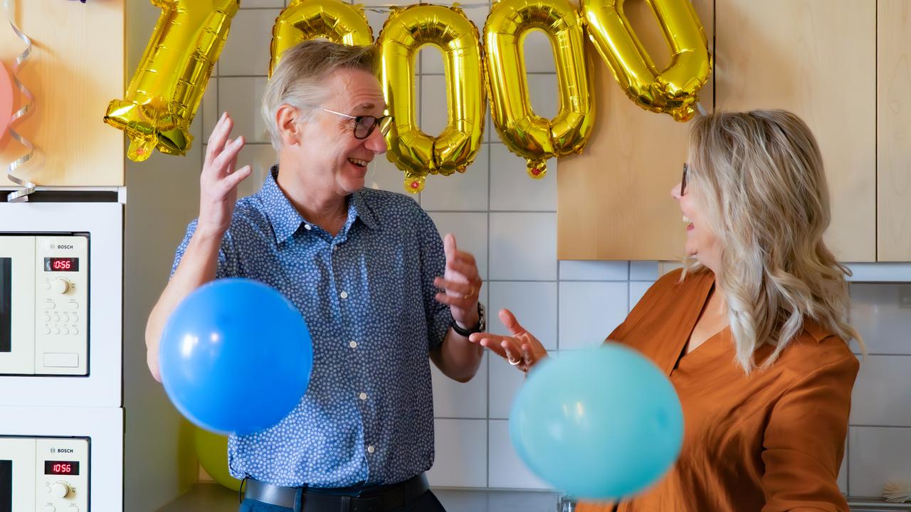 En man och en kvinna i ett kök med ballonger.