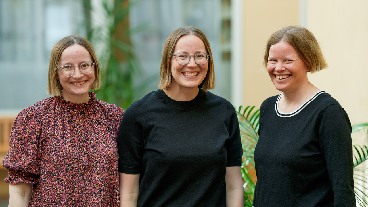 Tre systrar som står porträtterade bredvid varandra.