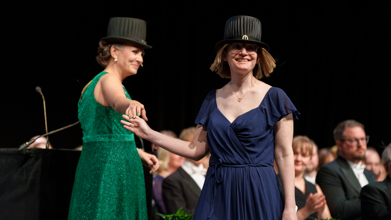 Kvinna leder annan kvinna på scen