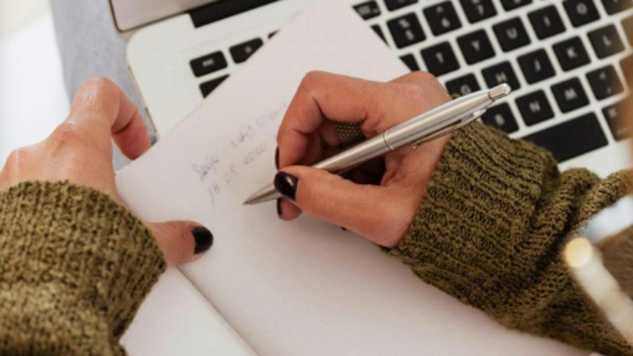 Hands writing on paper