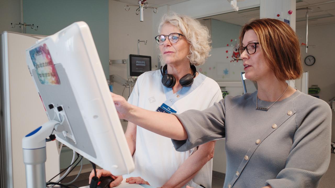 Två kvinnor framför en datorskärm.