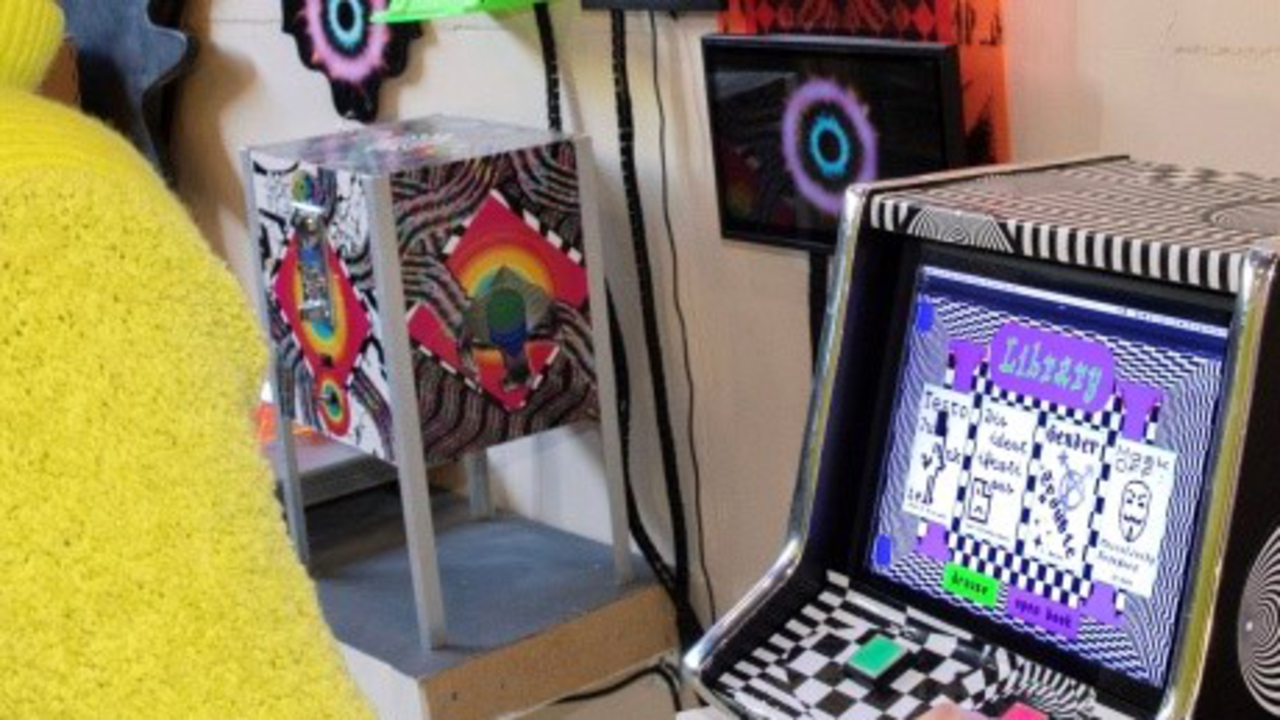 Person som trycker på en rosa knapp på en maskin med många färger