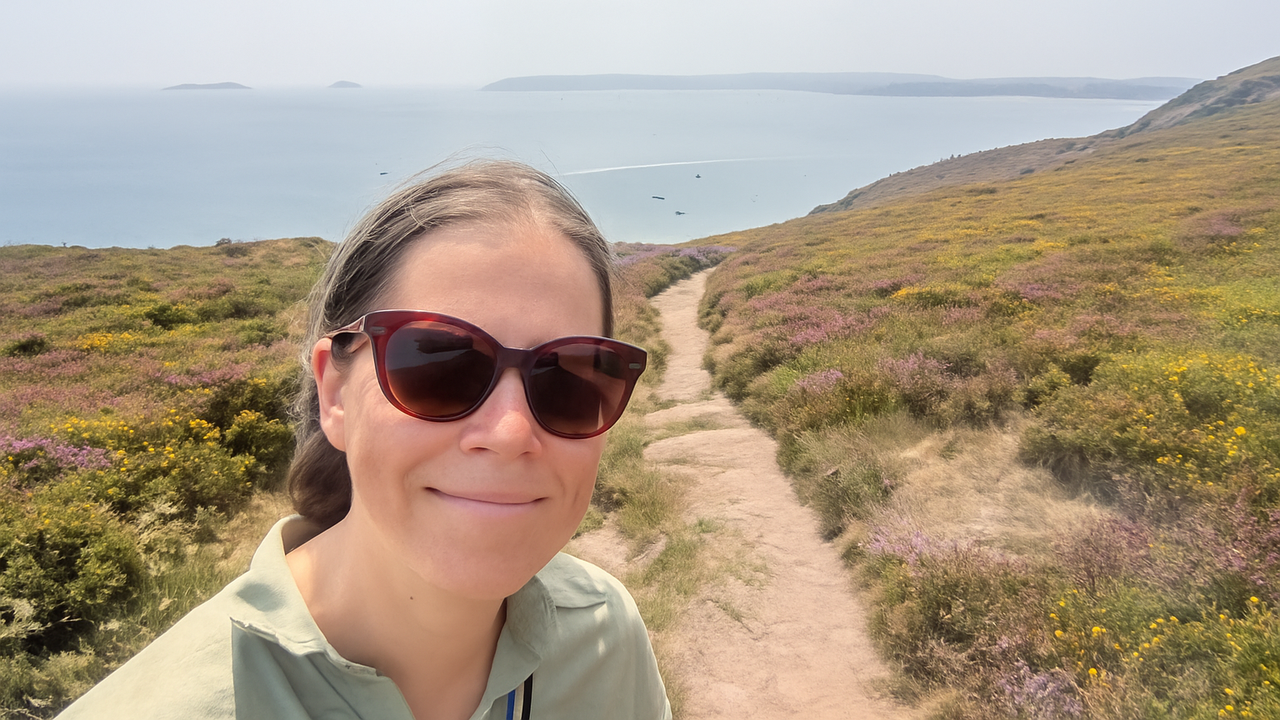 Porträttbild i naturskön miljö med havet i bakgrunden.