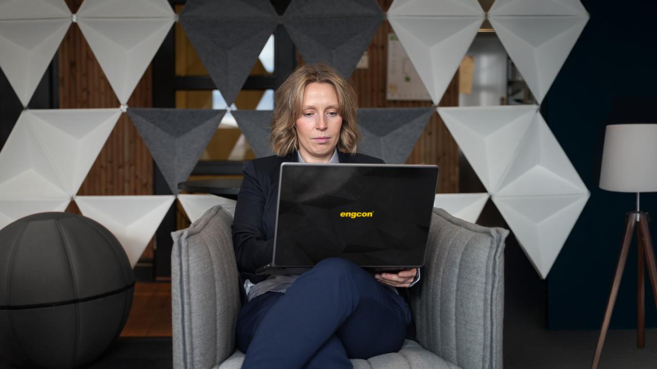 En kvinna sitter i en stol med en bärbar dator.