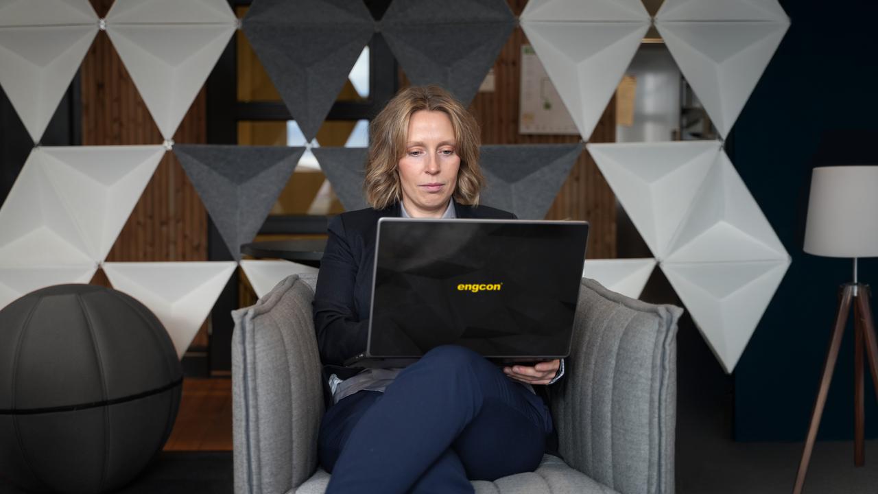 En kvinna sitter i en stol med en bärbar dator.