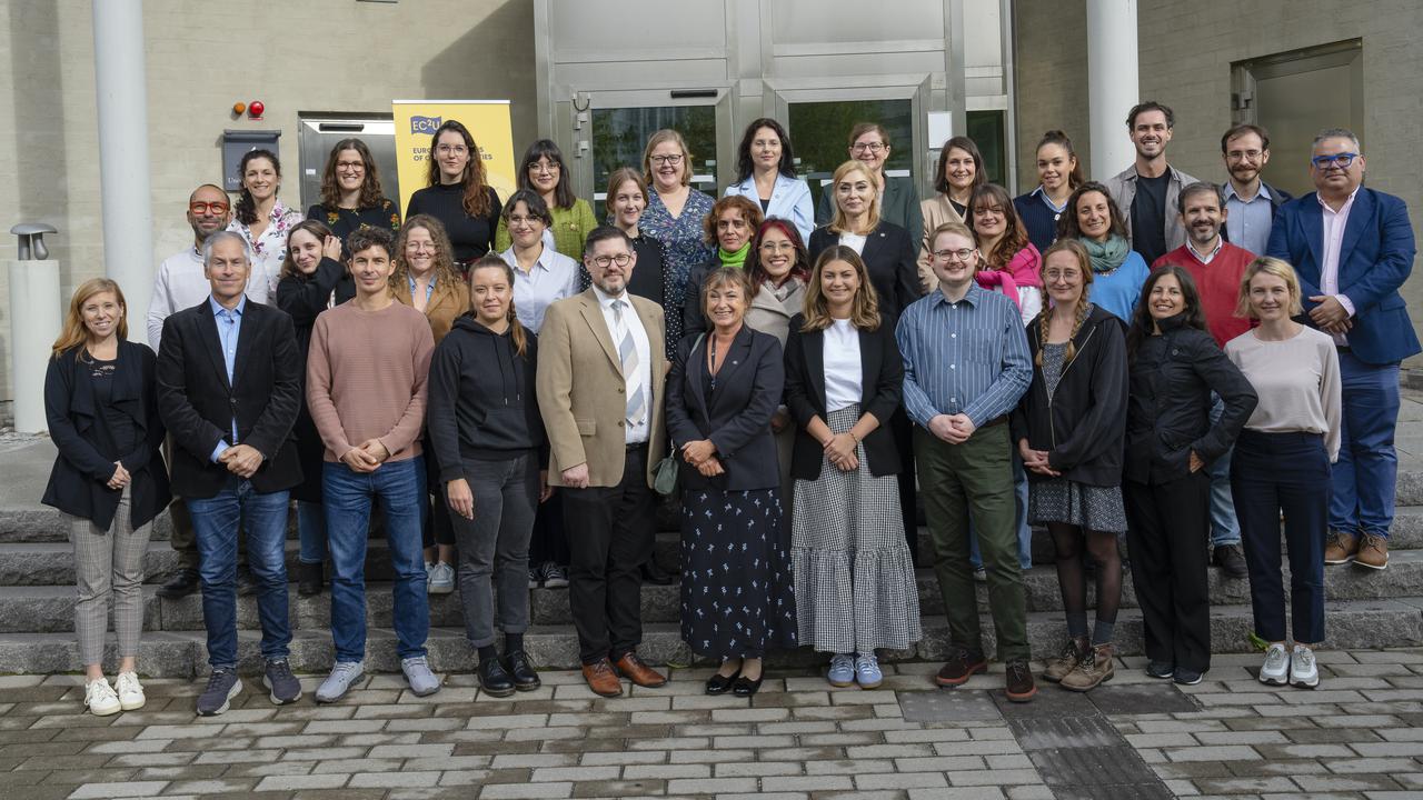 Group photo of EC2U university delegates in front of a campus building