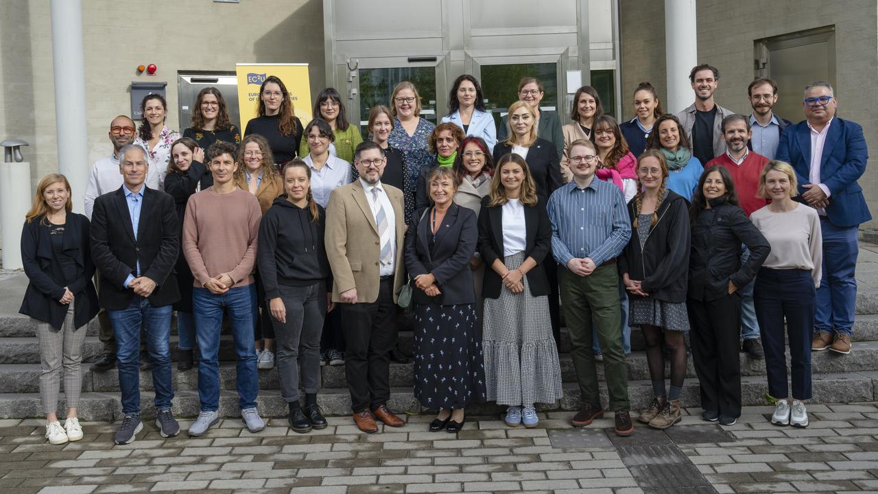 Group photo of EC2U university delegates in front of a campus building